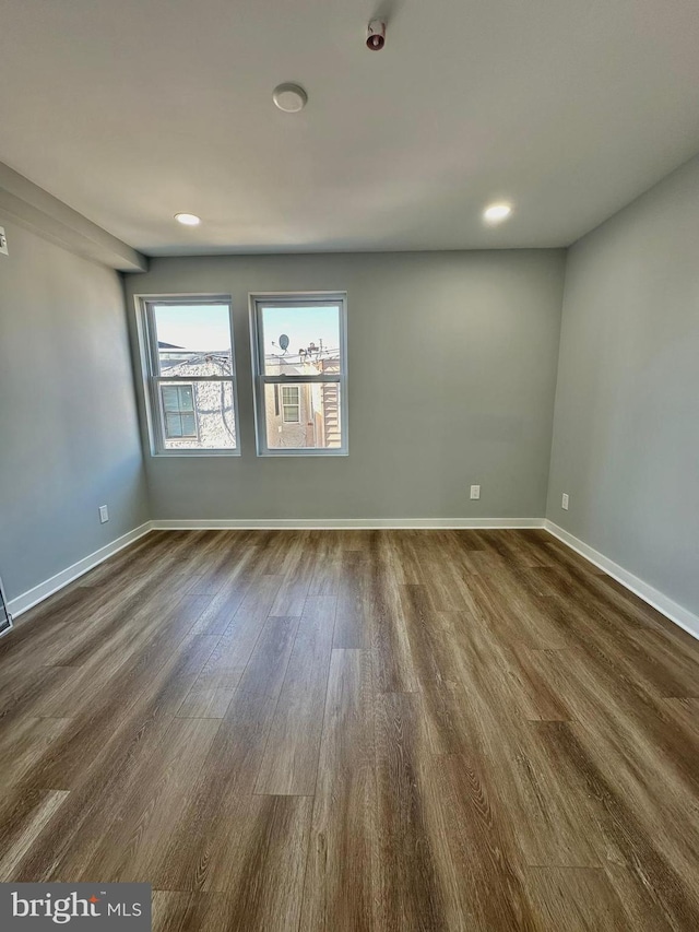 unfurnished room with dark wood-type flooring