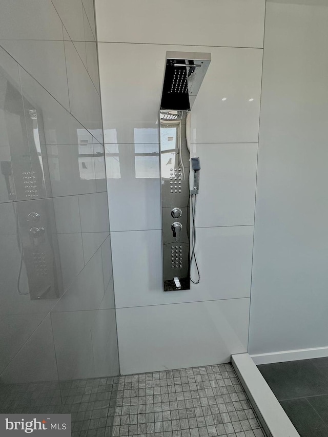 room details with dark tile flooring and tiled shower