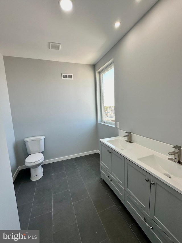 bathroom with dual bowl vanity, toilet, and tile flooring