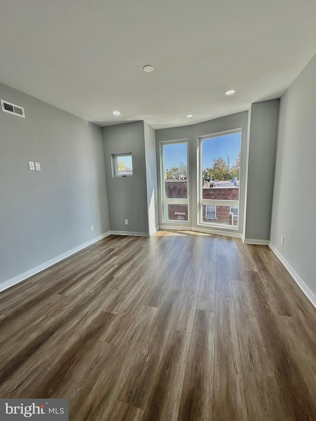 unfurnished room with dark hardwood / wood-style flooring