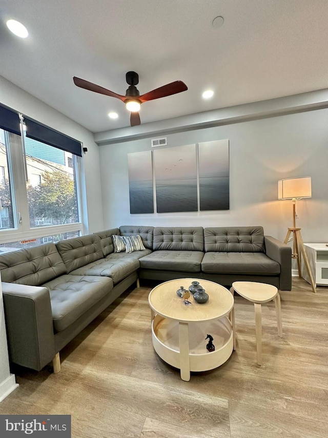 living room with light hardwood / wood-style floors and ceiling fan