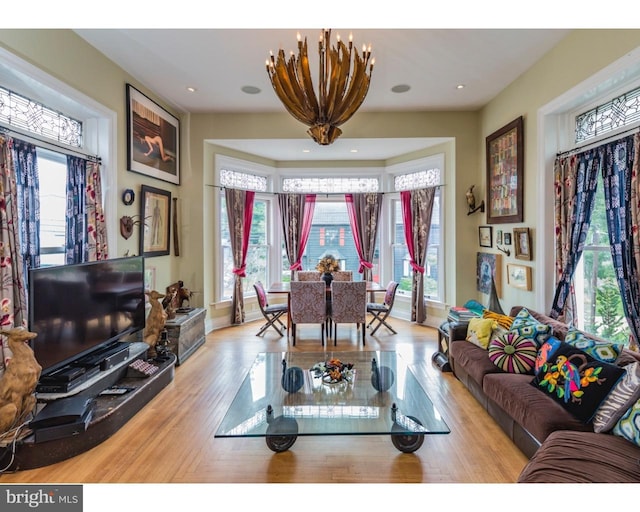 living room with a chandelier and light wood-type flooring