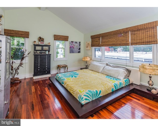 bedroom with vaulted ceiling and dark hardwood / wood-style flooring