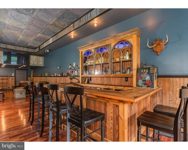 bar featuring dark hardwood / wood-style flooring and butcher block counters