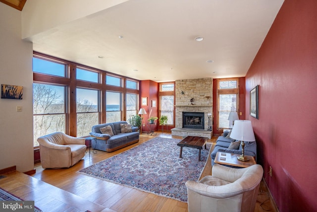 living room with a stone fireplace and light hardwood / wood-style floors