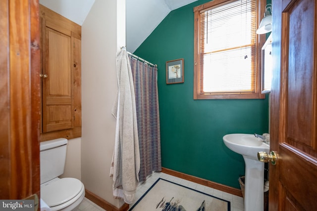 bathroom with plenty of natural light, toilet, and lofted ceiling