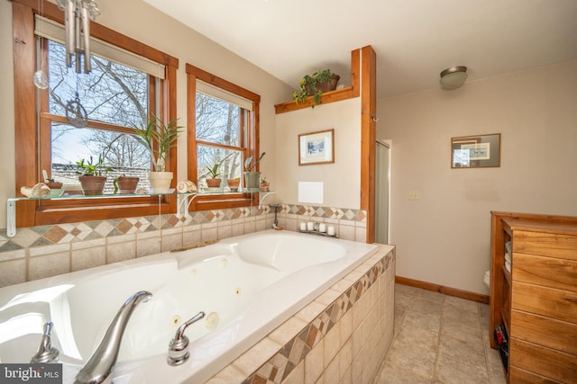 bathroom with tile patterned floors and a relaxing tiled tub