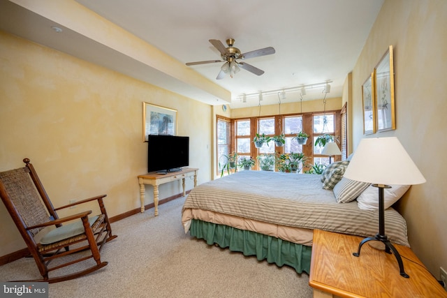 carpeted bedroom with track lighting and ceiling fan