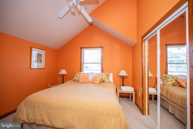 bedroom featuring light colored carpet, vaulted ceiling, multiple windows, and ceiling fan