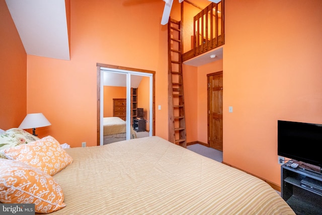 carpeted bedroom featuring a high ceiling and a closet