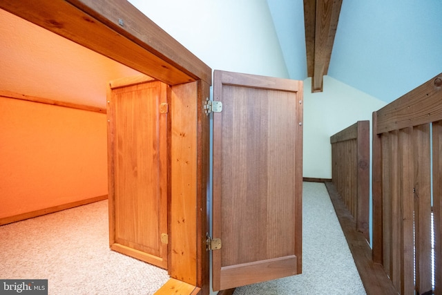 hall featuring lofted ceiling with beams and carpet floors