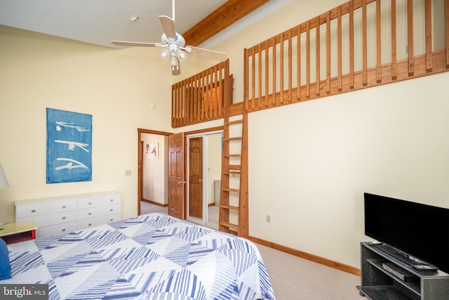 bedroom with beamed ceiling, ceiling fan, a towering ceiling, and carpet floors