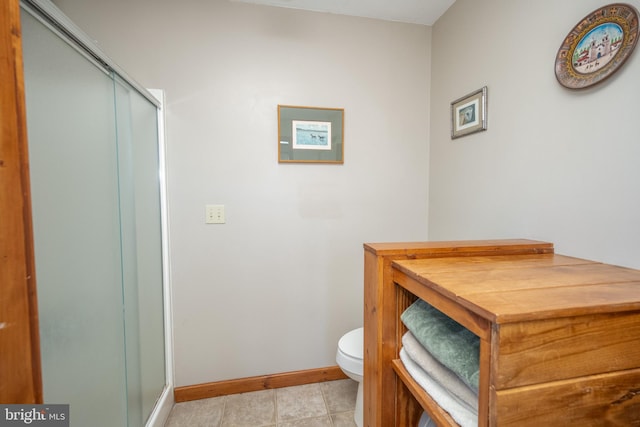 bathroom with tile patterned flooring, an enclosed shower, and toilet