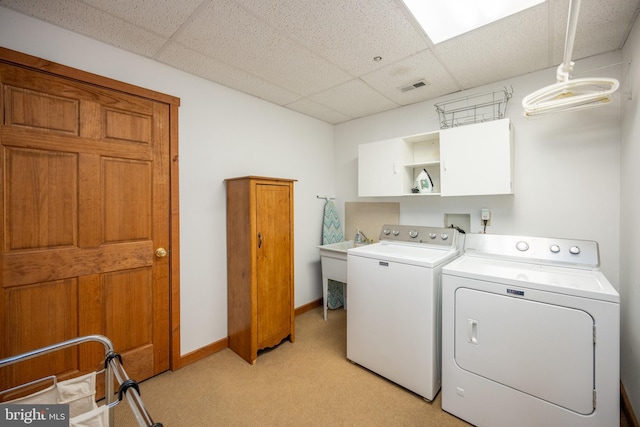 washroom featuring light carpet, sink, cabinets, and independent washer and dryer