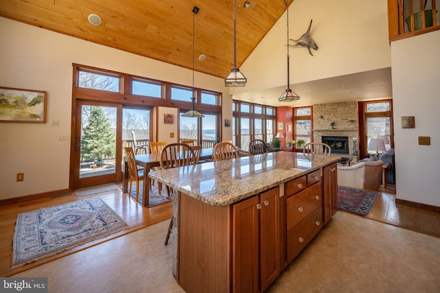 kitchen featuring a center island, high vaulted ceiling, decorative light fixtures, a kitchen bar, and wood ceiling