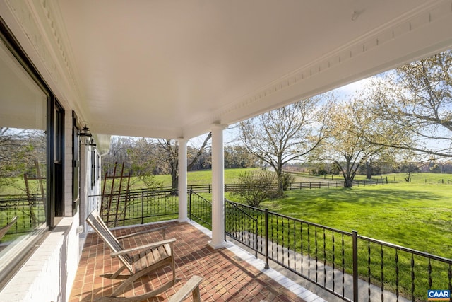 wooden terrace featuring a rural view and a lawn