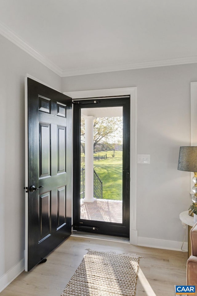 doorway to outside featuring crown molding and light wood-type flooring