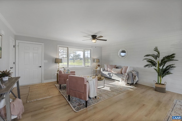 living room with ceiling fan, crown molding, and light hardwood / wood-style floors