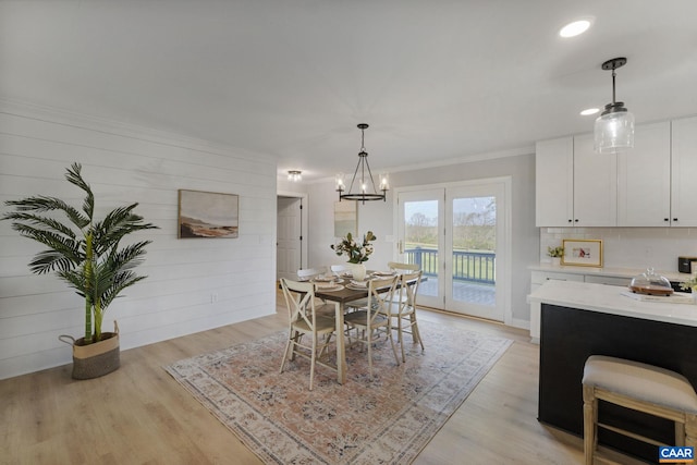 dining area featuring light hardwood / wood-style floors, ornamental molding, and a chandelier