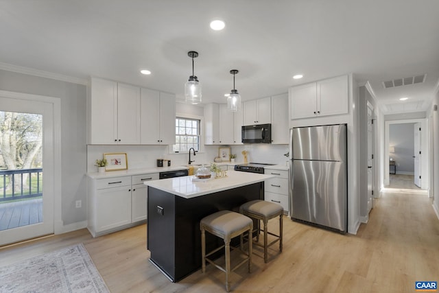 kitchen with light hardwood / wood-style flooring, stainless steel fridge, a wealth of natural light, and a center island