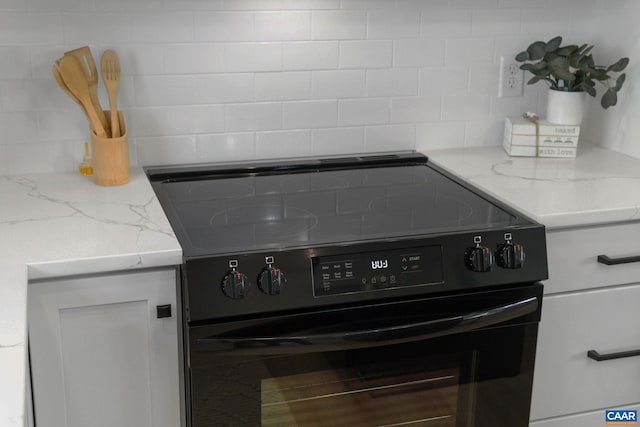 details featuring tasteful backsplash and electric range