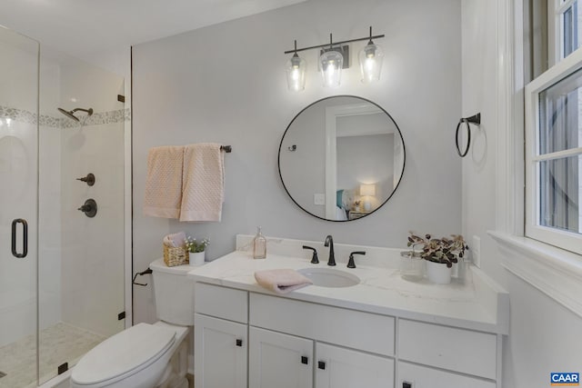 bathroom with toilet, large vanity, and a shower with shower door