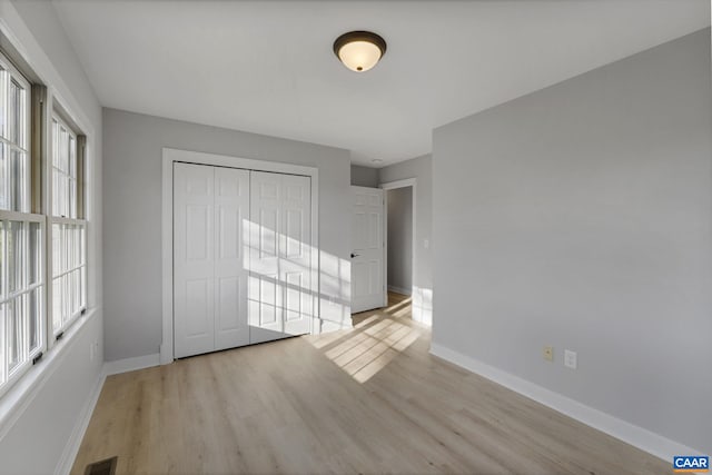 unfurnished bedroom with a closet and light hardwood / wood-style flooring