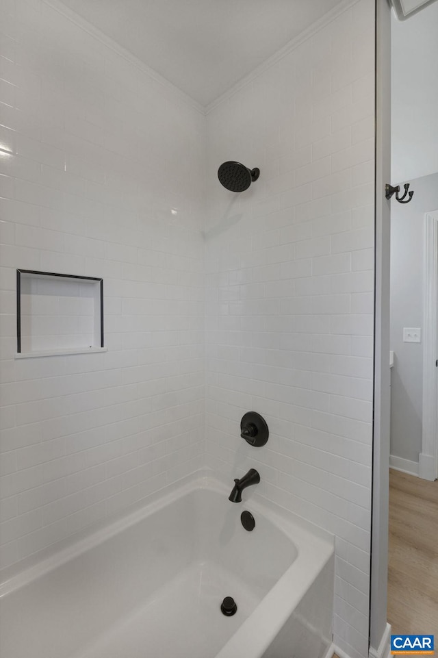 bathroom with tiled shower / bath combo, wood-type flooring, and crown molding