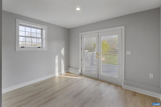 unfurnished room featuring french doors and light hardwood / wood-style flooring