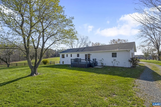 rear view of property with a lawn and a wooden deck