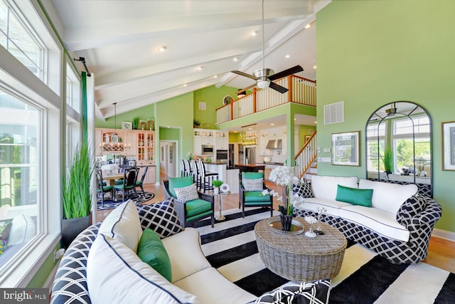 living room featuring ceiling fan, beam ceiling, high vaulted ceiling, and wood-type flooring