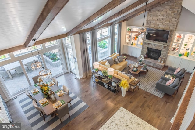 living room featuring beam ceiling, a fireplace, and a healthy amount of sunlight