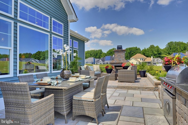 view of patio / terrace featuring an outdoor living space with a fireplace and exterior kitchen