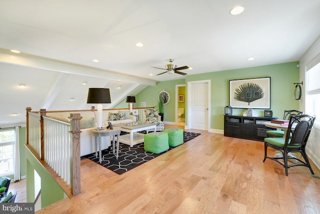 living room with ceiling fan, vaulted ceiling with beams, and light wood-type flooring