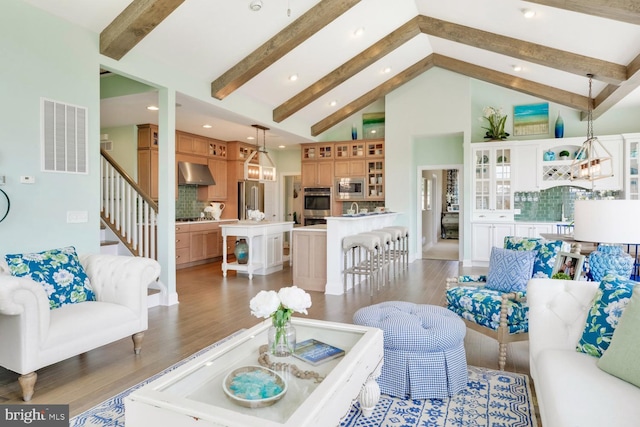 living room with high vaulted ceiling, light wood-type flooring, and beamed ceiling