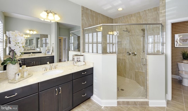 bathroom with toilet, tile flooring, a shower with shower door, and vanity