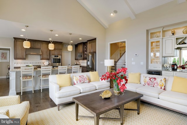 living room featuring beam ceiling, high vaulted ceiling, and light hardwood / wood-style floors