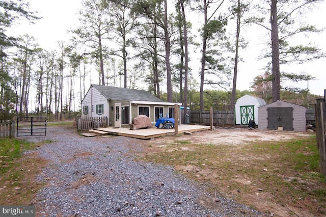 back of property with a shed and a wooden deck