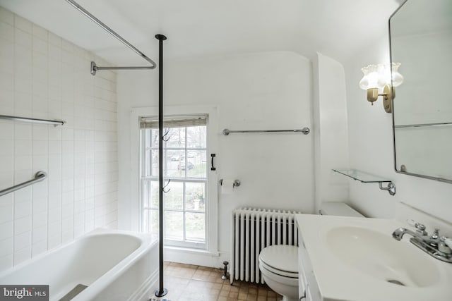 full bathroom with vanity, tiled shower / bath combo, toilet, and radiator