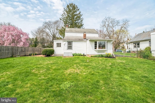 back of property featuring a lawn