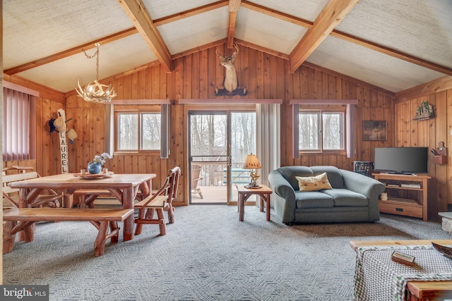 living room with wooden walls, carpet, lofted ceiling with beams, a notable chandelier, and a textured ceiling