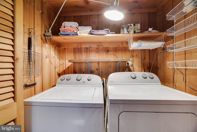 laundry area with independent washer and dryer and wooden walls