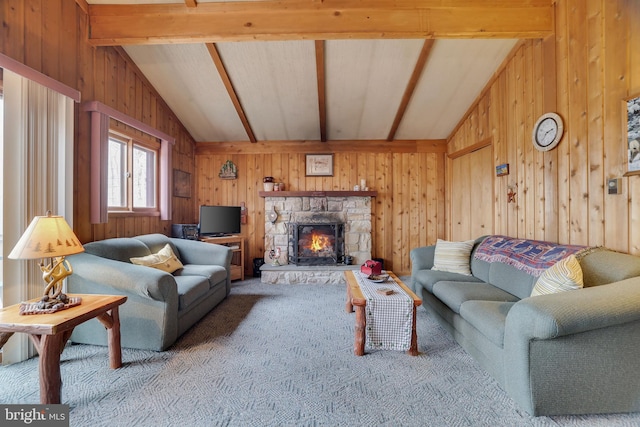 living room featuring vaulted ceiling with beams, light colored carpet, wood walls, and a stone fireplace