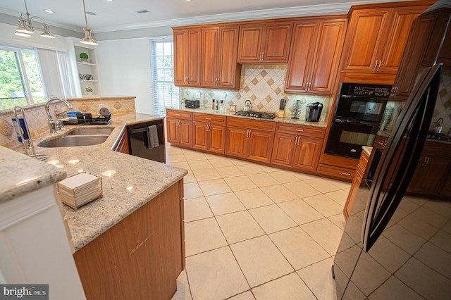 kitchen with tasteful backsplash, light stone counters, crown molding, sink, and decorative light fixtures