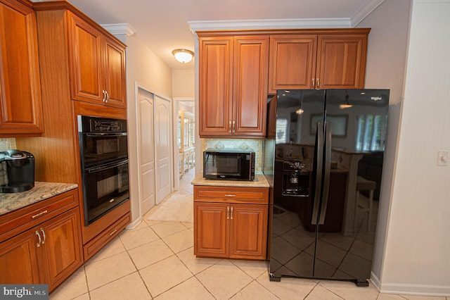 kitchen with light stone countertops, light tile patterned floors, ornamental molding, and black appliances