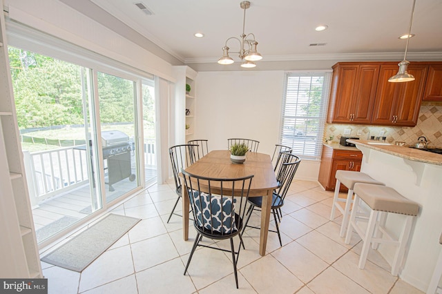 tiled dining space with a chandelier and crown molding