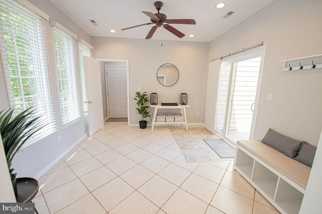 entrance foyer featuring ceiling fan, light tile patterned floors, and a wealth of natural light