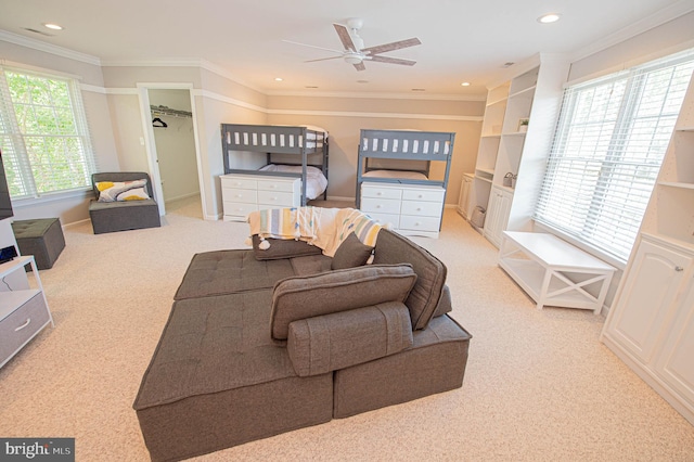 bedroom featuring a walk in closet, crown molding, a closet, and multiple windows