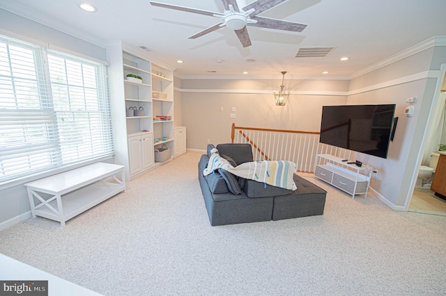 living room featuring ceiling fan with notable chandelier, carpet floors, and crown molding