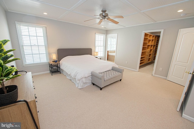 carpeted bedroom with a walk in closet, ensuite bathroom, a closet, and ceiling fan